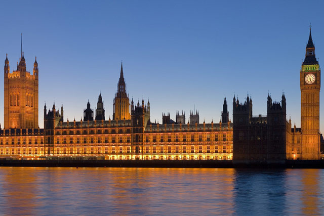 The Palace of Westminster at night seen from the south bank of the River Thames.