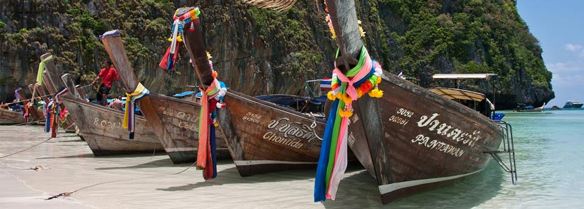 A group of long-tailed boats anchored in Maya Bay on Phi Phi Ley island in southern Thailand.